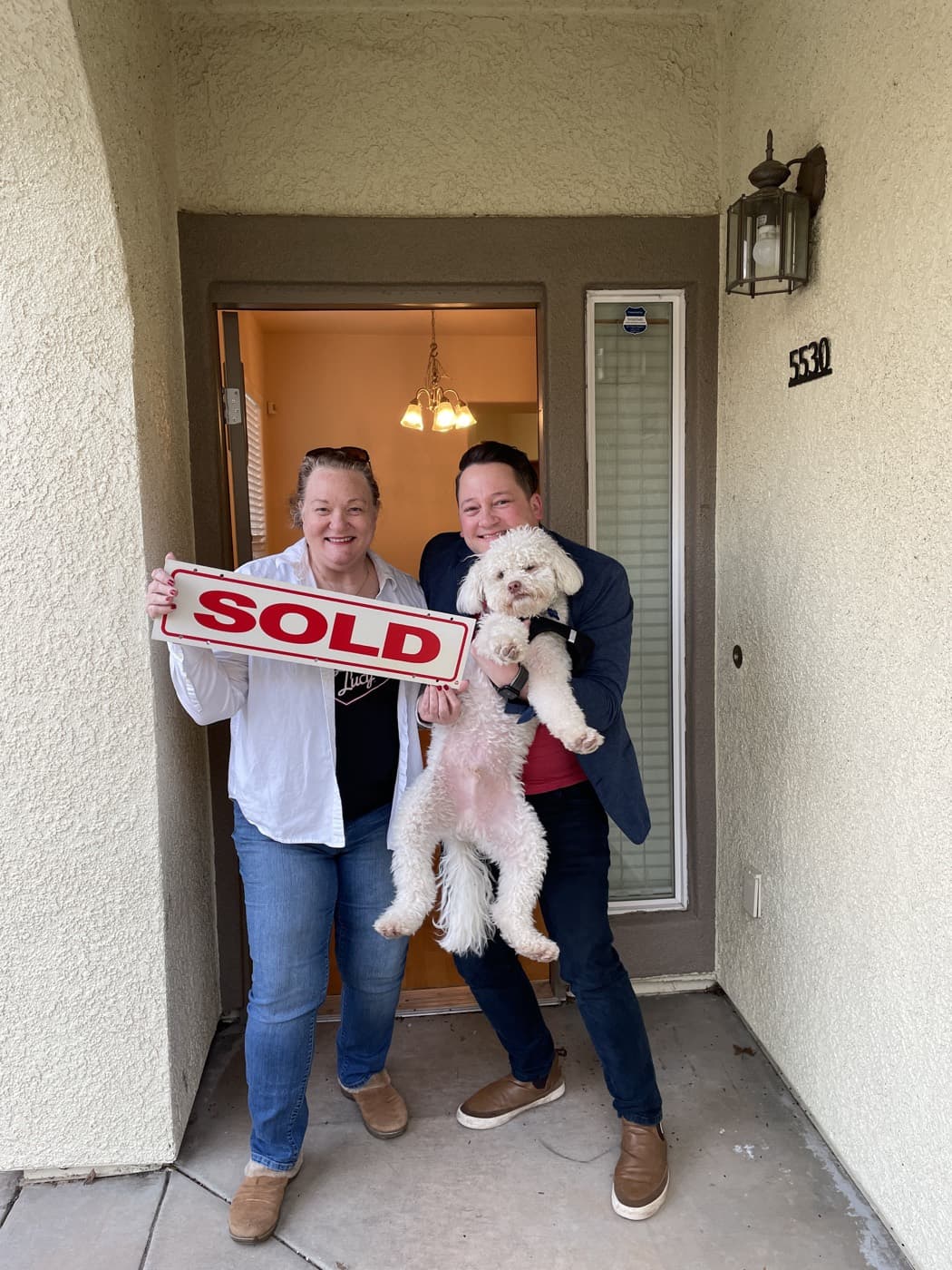 Clients and their dog celebrating a home purchase
